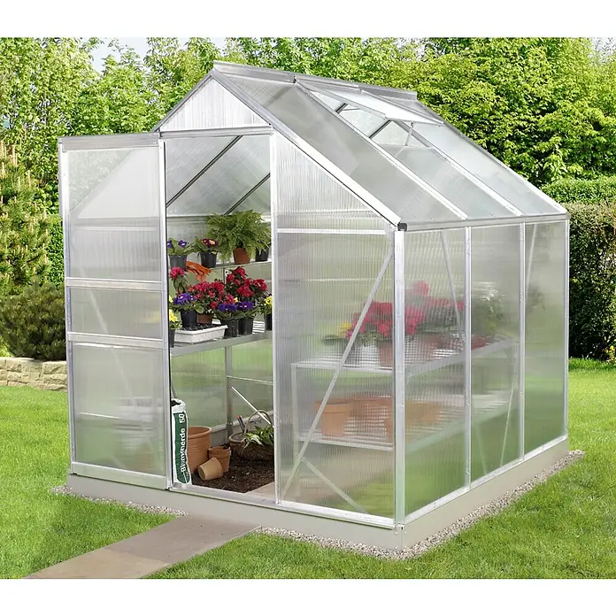 Vitavia Gewächshaus Venus 3800 Plus - Außenmaß inkl. Dachüberstand (B x T): 195 x 195 cm, 4 mm, Aluminium - Ein Gewächshaus mit geöffneter Tür, gefüllt mit Pflanzen und Blumen, steht in einem grünen Garten.