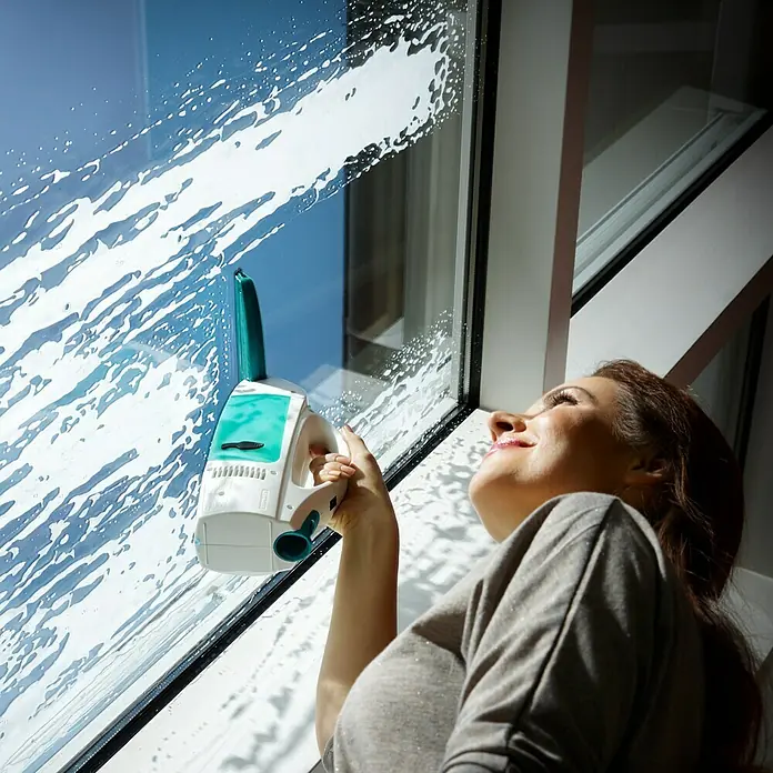 Leifheit Akku-Fenstersauger Dry & Clean - 1 Akku, Behältervolumen: 0,1 l - Frau putzt Fenster mit einem Leifheit Fensterreiniger für ein sauberes und streifenfreies Ergebnis.