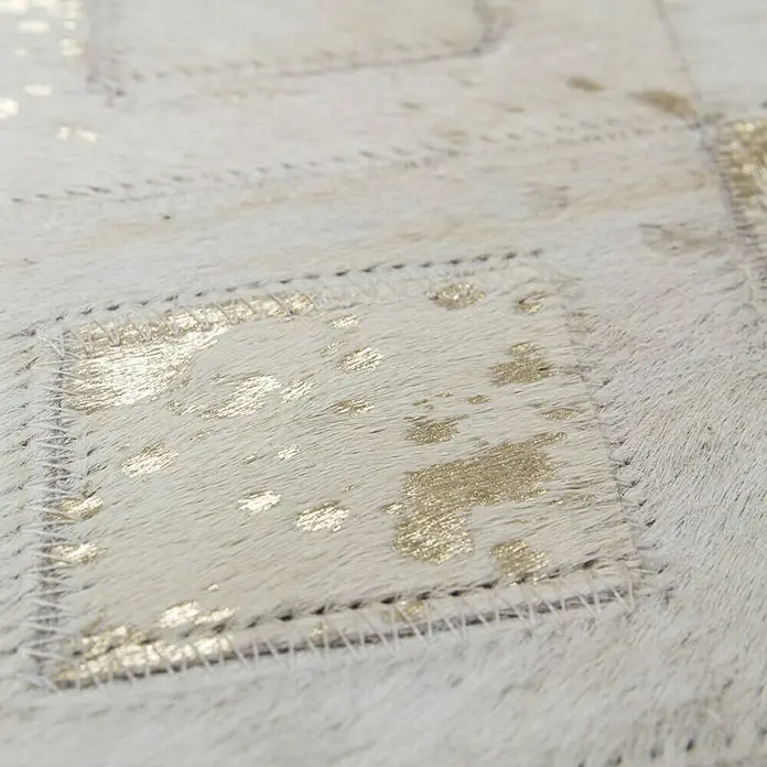 Kayoom Lederteppich Dazzle 100 - Elfenbein/Gold, 170 x 120 cm, 100 % Leder - Nahaufnahme eines stilvollen Teppichs mit goldenen Akzenten und einem einzigartigen, luxuriösen Design.