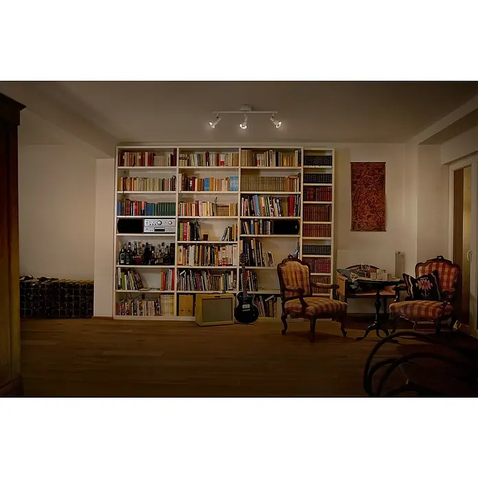 Ledvance Deckenstrahler Spot - 10,2 W, L x B x H: 48,6 x 9 x 15,5 cm, Weiß, GU10, 3 Stk. - Bücherregal mit Gitarre und Verstärker in einem gemütlichen Wohnzimmer, beleuchtet durch eine Deckenleuchte mit drei Spots. Eine einladende Leseecke.