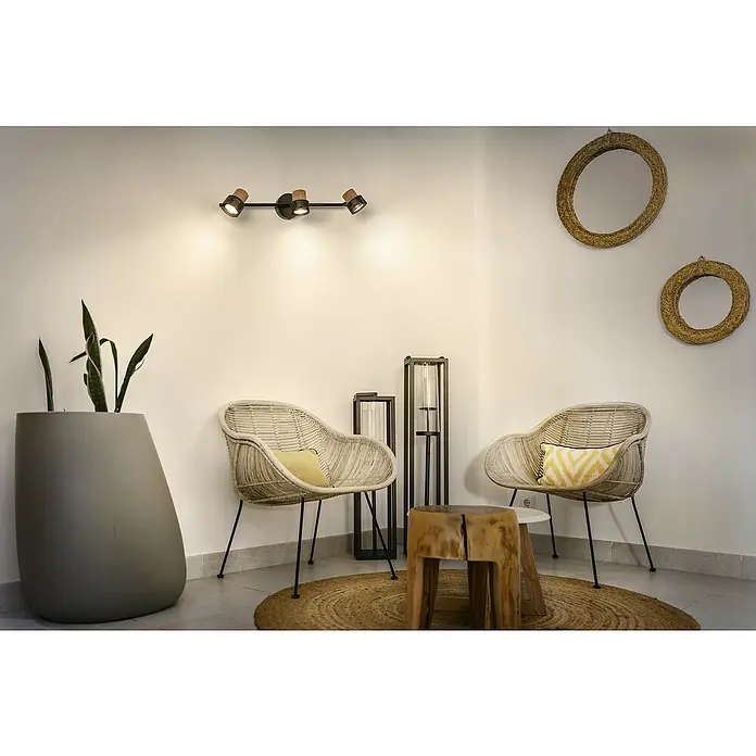 Osram Wandstrahler Spot Cork - 10,2 W, L x B x H: 57,7 x 10 x 13,6 cm, Schwarz, GU10, 3 Stk. - Ein stilvolles Interieur mit zwei Rattansesseln, einem Holzhocker und einer modernen Deckenleuchte, die den Raum erhellt.