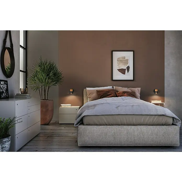 Ledvance Wandstrahler Spot Cork - 3,4 W, L x B x H: 9 x 12,6 x 10,1 cm, Schwarz, GU10, 1 Stk. - Schlafzimmer mit einem Doppelbett, Nachttischen und einer Kommode. Das Zimmer ist in warmen Farben gehalten und mit Pflanzen dekoriert.