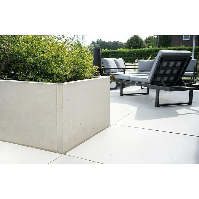 Diephaus Hochbeet - 210 x 100 x 80 cm, Beton, Grau - Nahaufnahme eines modernen, quadratischen Betonpflanzgefäßes im Freien, das ein üppiges grünes Gewächs enthält. Die klaren Linien ergänzen die Gartenmöbel.