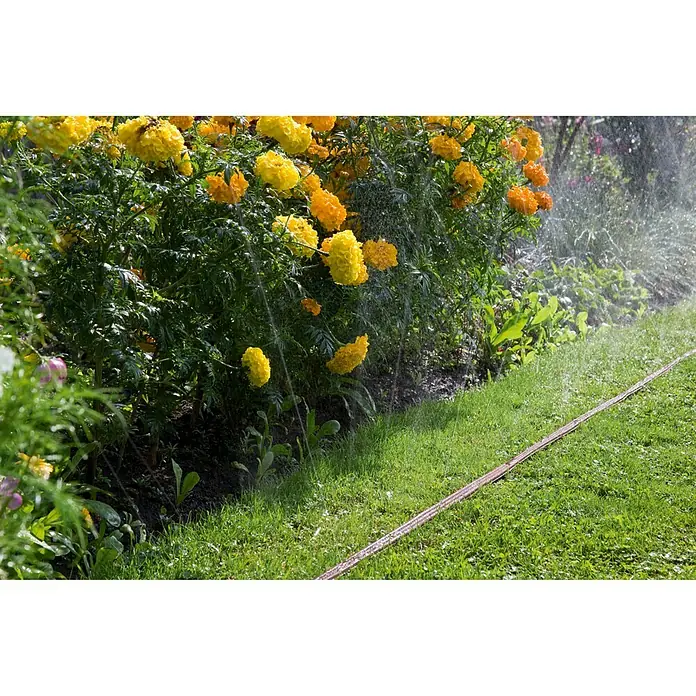 Gardena Schlauchregner - Braun, 15 m - Bewässerungssystem im Garten mit gelben Blumen und einem Bewässerungsschlauch.