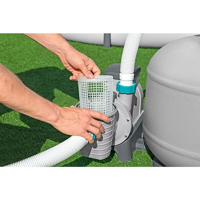 Bestway Sandfilteranlage - Filterleistung: 7.570 l/h, Passend für Poolgröße: 60.500 l - Ein Mann setzt einen Filter in eine Poolpumpe ein. Die Poolpumpe ist grau und hat einen weißen Schlauchanschluss.