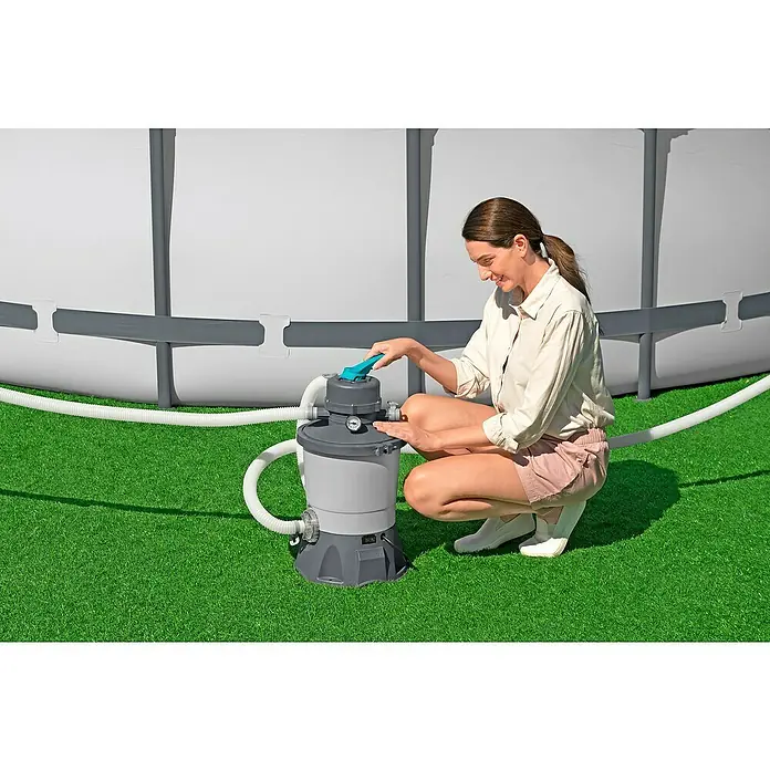 Bestway Sandfilteranlage - Filterleistung: 2.082 l/h, Passend für Poolgröße: 16.600 l - Frau bedient eine Poolfilterpumpe im Freien, um die Wasserqualität zu erhalten. Sie passt Einstellungen an für sauberes Poolwasser.