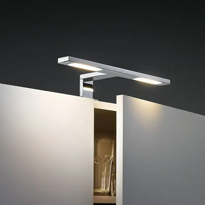 Paulmann Galeria LED-Spiegelleuchte Double Hook - 6,4 W, L x B x H: 30 x 11 x 8 cm, Chrom, Warmweiß - Eine stilvolle Chrom-LED-Schrankleuchte beleuchtet ein offenes weißes Regal und setzt Gläser in Szene. Elegante und praktische Beleuchtungslösung.