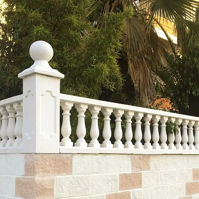 Pasamano Palermo - Hormigón - Primer plano de una valla de balaustrada blanca con pilares decorativos y una parte superior redondeada, que proporciona un límite elegante.