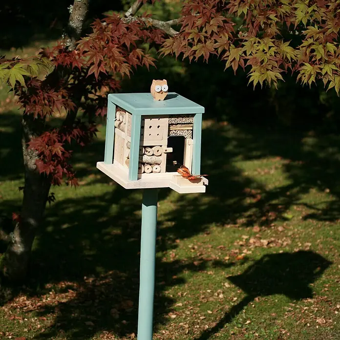 Dobar Insektenhotel Kubus - 27 x 27 x 105 cm, Holz, Grün/Blau - Nahaufnahme eines stilvollen Insektenhotels mit dekorativer Eule, das einen sicheren Unterschlupf für nützliche Insekten bietet.