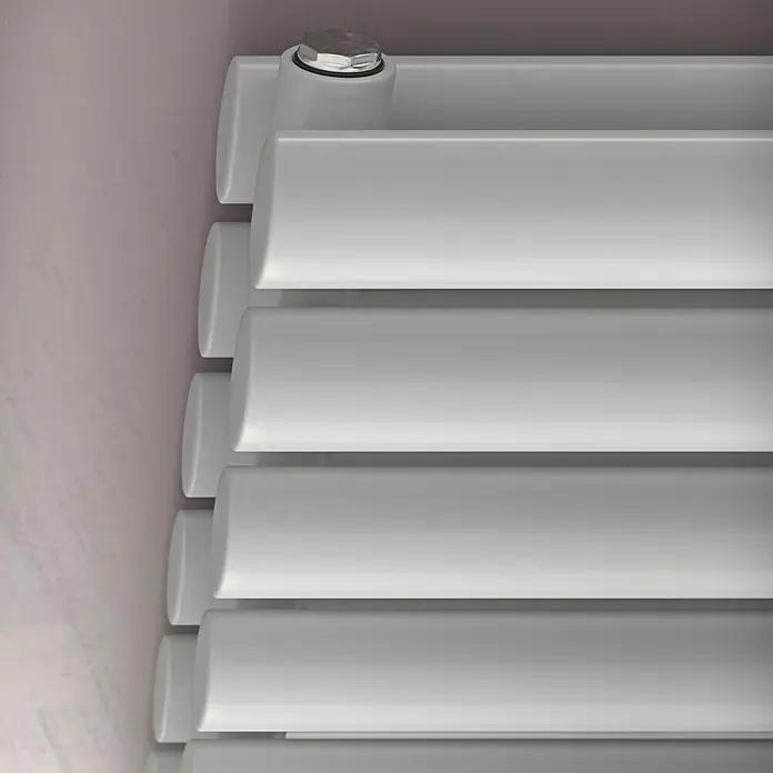 Ximax Raumheizkörper Fortuna Duplex - B x H: 1.200 x 584 mm, Wärmeleistung bei Vorlauftemperatur von 75 °C (D: 50): 1.204 W, Weiß - Nahaufnahme eines modernen, horizontalen Heizkörpers in Weiß, der an einer hellrosa Wand montiert ist. Die elegante Bauweise sorgt für Wärme und Stil.