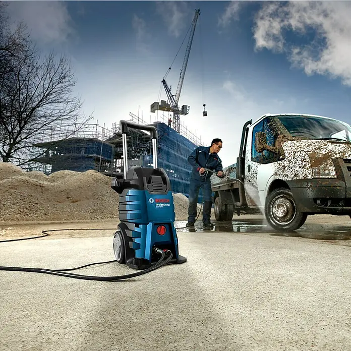 Bosch Professional Hochdruckreiniger GHP 5-55 - 130 bar, 2.200 W, Fördermenge: 520 l/h - Bild eines Bosch Professional Hochdruckreinigers GHP 5-55 im Einsatz, der einen Lieferwagen auf einer Baustelle reinigt.