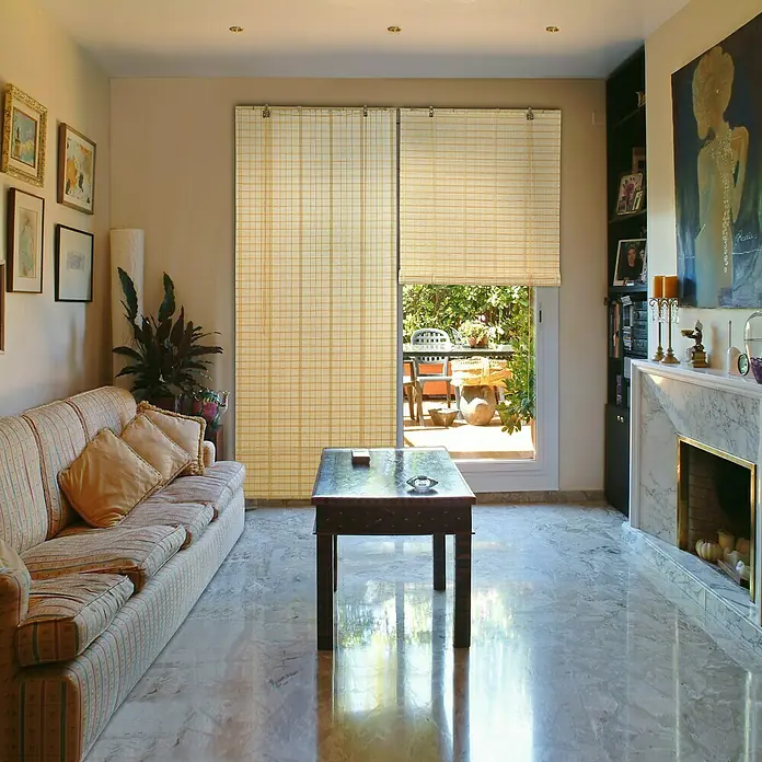 Estor enrollable Safari - An x Al: 120 x 175 cm, Naranja - Salón con sofá, mesa y persianas enrollables en la puerta del patio, parcialmente abiertas para una vista exterior.