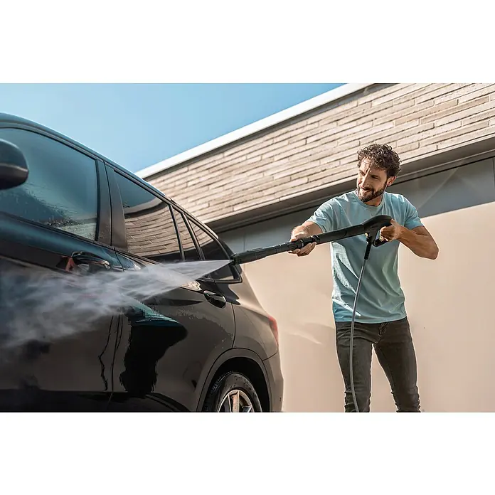 Kärcher Hochdruckreiniger K 7 WCM Pure Flex Home - 3.000 W, Max. Druck: 180 bar, Fördermenge: 600 l/h - Ein Mann benutzt einen Kärcher Hochdruckreiniger, um sein schwarzes Auto zu waschen, wobei der Wasserstrahl den Schmutz löst.