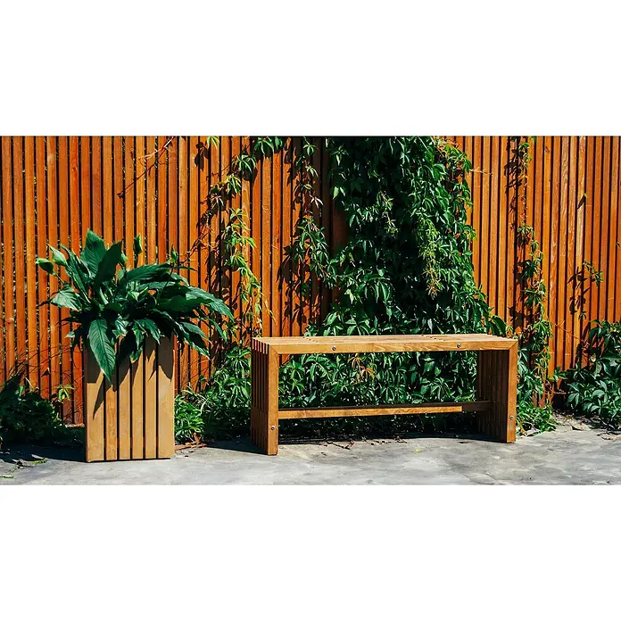 Andrewex Sichtschutzelement Quadra - 180 x 90 cm, Holz, Kiefer - Eine Gartenbank und ein Pflanzenkasten aus Holz stehen vor einem Holzzaun, der mit Grünzeug bewachsen ist.