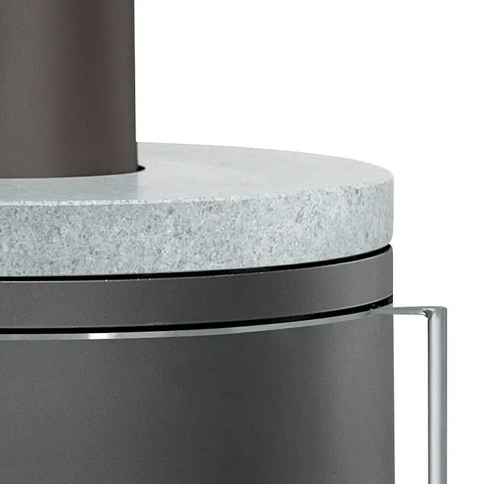 Justus Kaminofen Faro 2.0 - 6 kW, Raumheizvermögen: 115 m³, Verkleidung: Stahl/Speckstein, Schwarz - Nahaufnahme eines Kamins mit Steinplatte, der modernes Design und hochwertige Materialien vereint.