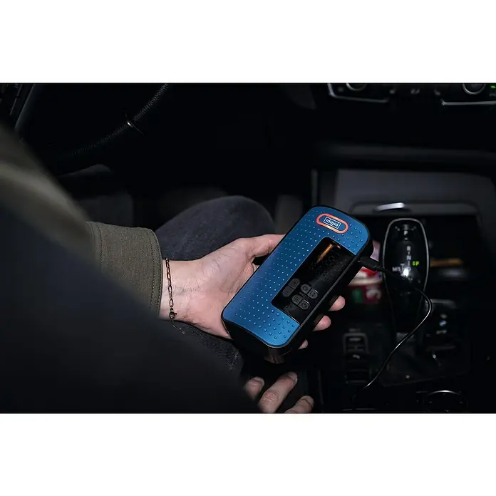 Scheppach Akku-Kompressor AC10/8V - 8 V, 1 Akku, 2 Ah, Max. Druck: 10,3 bar - Nahaufnahme eines blauen Scheppach-Radios mit orangefarbenen Akzenten, das in einem Auto gehalten wird.