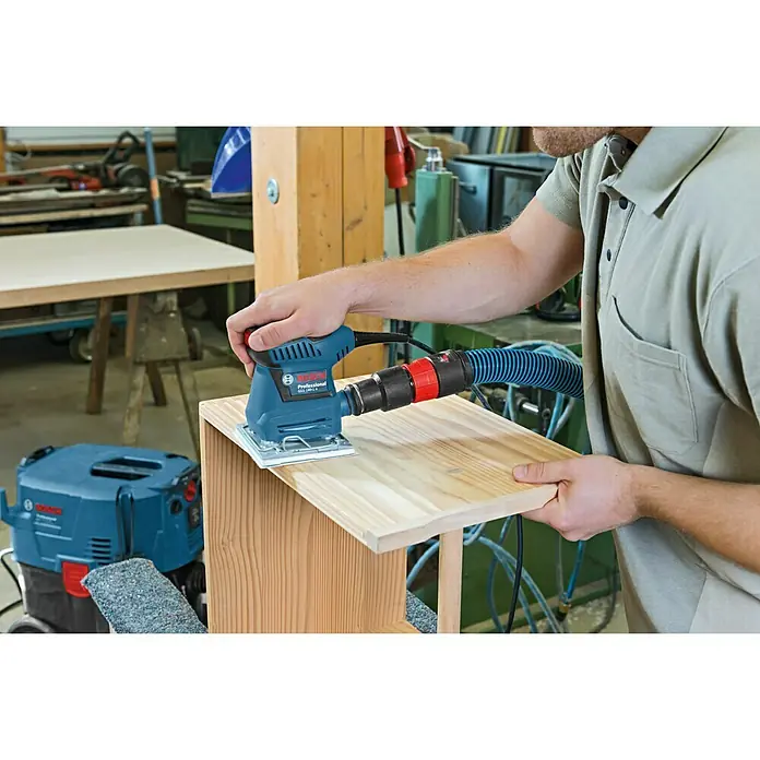 Bosch Professional Lijadora orbital eléctrica GSS 140-1A - 180 W, Número de oscilaciones marcha en vacío: 24.000 r.p.m. - Se está utilizando una lijadora Bosch Professional para lijar una pieza de madera.