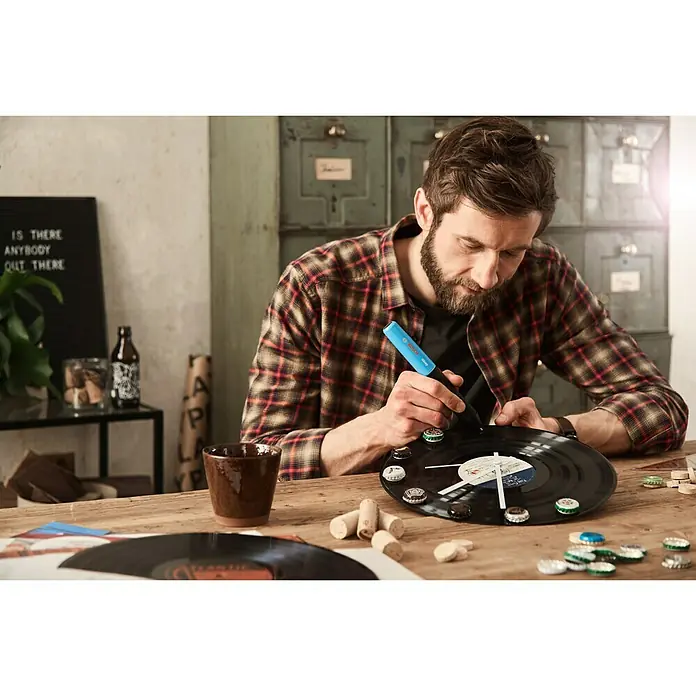 Bosch Akku-Heißklebestift Gluey - Farbe: Smoky Grey - Mann bastelt eine Uhr aus einer Schallplatte mit dem Bosch Gluey Heißklebestift. Tolle DIY-Idee mit dem Bosch Gluey.