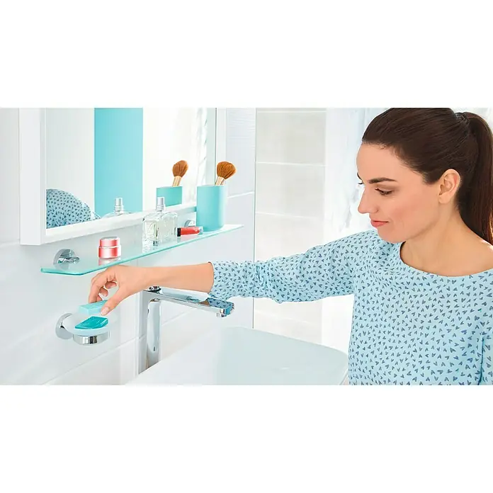 Tesa Smooz Seifenschale - Mit Halterung, Satiniert/Chrom, Glänzend - Frau im Badezimmer, die ein Stück Seife in einer Seifenschale am Waschbecken platziert. Helle und moderne Badezimmerausstattung.