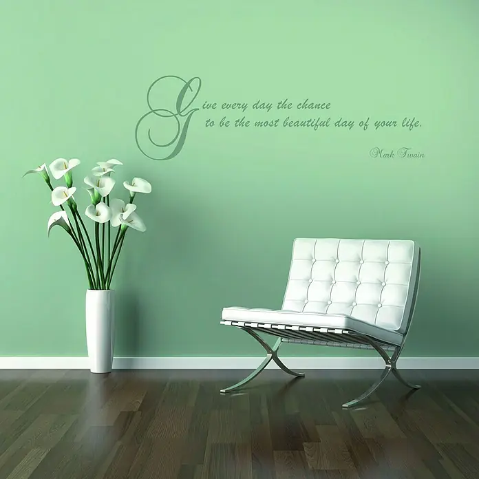 Komar Dekosticker Mark Twain - Beautiful - Silber, 100 x 70 cm - Einladendes Interieur mit einem stilvollen, weißen Barcelona-Sessel vor einer mintgrünen Wand mit einem inspirierenden Zitat.