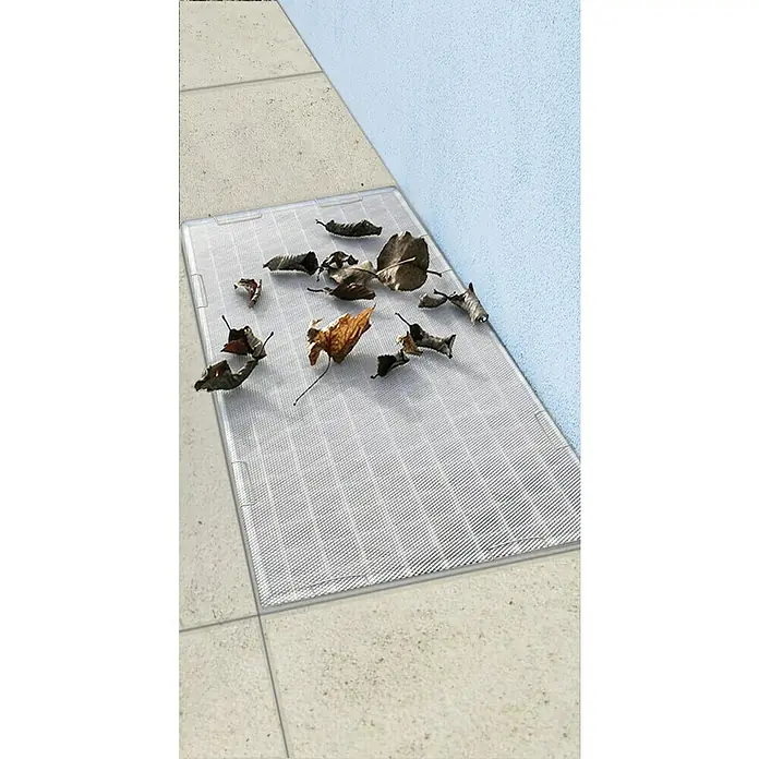 Easy Life Lichtschachtabdeckung - L x B: 60 x 120 cm, Stahl - Das Bild zeigt einen klaren, quadratischen Lichtschachtdeckel mit einer Ansammlung von trockenen Blättern darauf, der sich auf einer Fliese befindet.