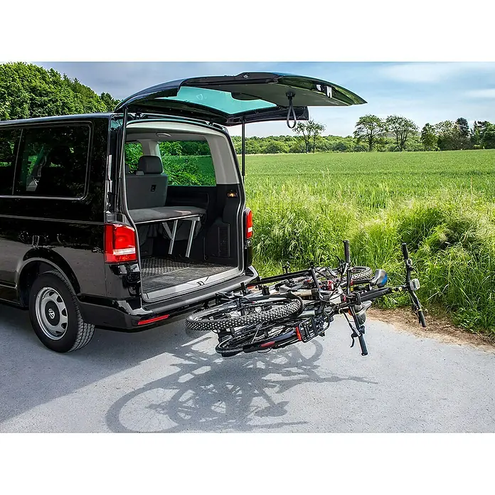 Eufab Fahrradträger Premium II Plus - Geeignet für: E-Bikes, Traglast: 60 kg - Heckansicht eines schwarzen VW-Busses mit geöffneter Heckklappe und montiertem Fahrradträger mit zwei Fahrrädern.