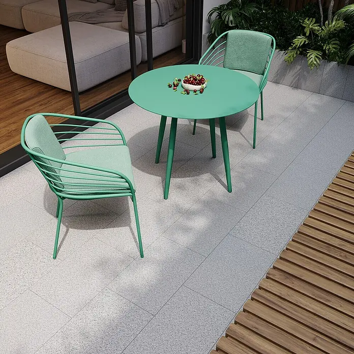 Terrassenplatte G 603 - 60 x 40 x 3 cm, Grau, Granit - Bild eines mintgrünen Gartentisches mit zwei Stühlen und einem Teller mit Früchten im Freien.