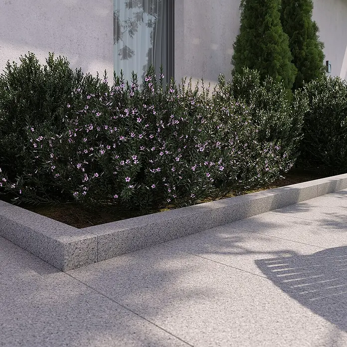 Palisade G 603 - 180 x 12 x 12 cm, Grau - Außenaufnahme von Pflanzen mit lila Blüten, die in einem erhöhten Beet aus Granitsteinen angeordnet sind.