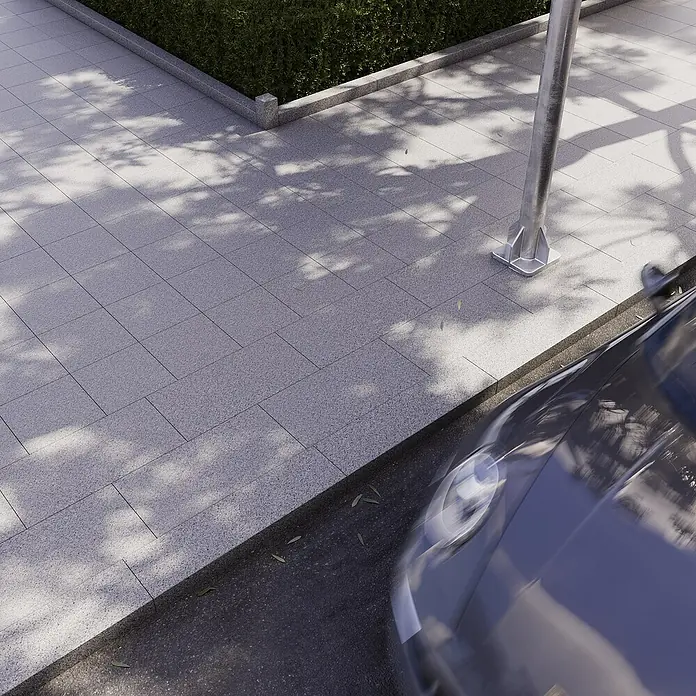 Terrassenplatte G 603 - 40 x 40 x 3 cm, Grau, Granit - Straßenaufnahme mit gepflastertem Gehweg, Straßenlaterne und einem Teil eines geparkten Autos, das das urbane Ambiente ergänzt.