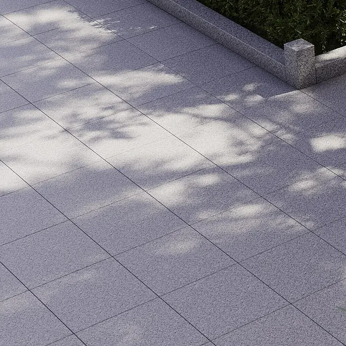 Terrassenplatte G 603 - 40 x 40 x 3 cm, Grau, Granit - Außenaufnahme von grauen Steinplatten mit Schattenmuster, die einen gepflegten und modernen Terrassenbereich bilden.