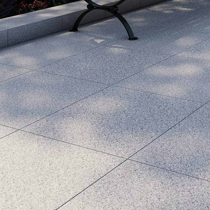 Terrassenplatte G 603 - 60 x 60 x 3 cm, Grau, Granit - Detailaufnahme einer hellgrauen Terrassenfläche mit quadratischen Pflastersteinen und dunklen Fugen.