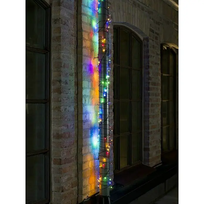 Konstsmide LED-Lichterkette - Außen, Lichtfarbe: Mehrfarbig, Anzahl Leuchtmittel: 80 Stk., Netzbetrieben, 12,64 m - Bunte Lichterkette um ein Regenrohr gewickelt, beleuchtet eine Backsteinwand und sorgt für eine festliche Atmosphäre im Freien.