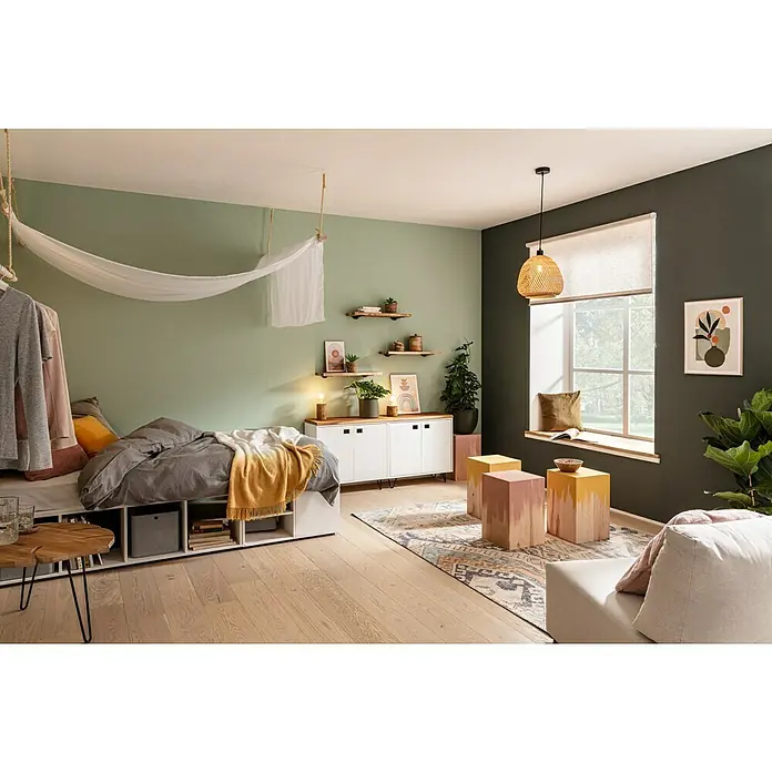 SCHÖNER WOHNEN-Farbe Naturell Wandfarbe InnenraumfarbeWeiß, Matt, 10 l, Konservierungsmittelfrei - Gemütliches Schlafzimmer mit einem Bett mit Stauraum, Holzbeistelltischen und einer hängenden Stoffdekoration.