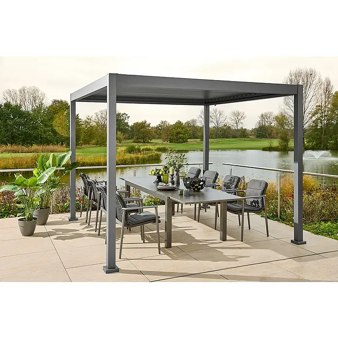 Sunfun Gartenmöbel-Set Maja/Solo/Milos - 18 -tlg., Night-Grey, Ausziehbar - Ein grauer Gartentisch mit Stühlen unter einer Pergola mit Blick auf einen ruhigen See, der Komfort und Stil für den Außenbereich bietet.