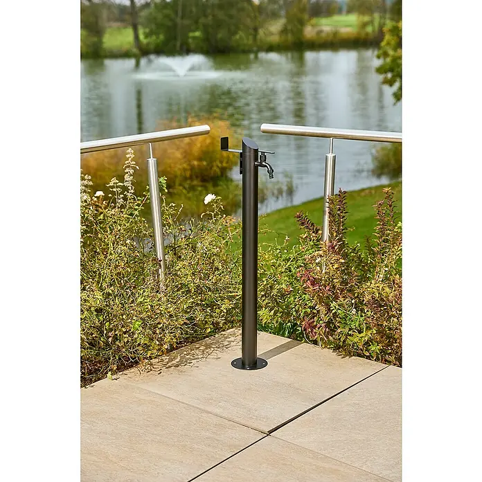 GardWell Wasserzapfstelle Comfort Style - Mattschwarz, Höhe: 93 cm, Edelstahl - Nahaufnahme eines modernen Wasserhahns im Freien neben einem Teich, ideal für Gärten und Außenbereiche.