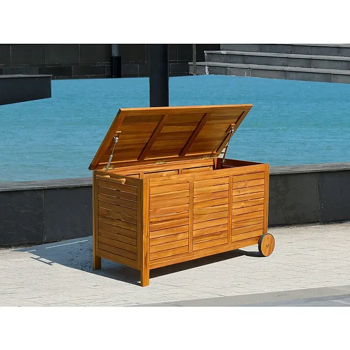 Baúl para jardín Amira - L x An x Al: 124 x 55,5 x 66 cm, Natural, Madera - Caja de jardín de madera abierta con ruedas en un patio exterior.