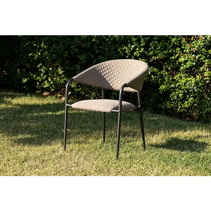 Stapelsessel - Stapelbar, Beige, B x T x H: 64,8 x 59,7 x 83 cm - Ein eleganter, gesteppter Sessel mit Armlehnen und schlanken, dunklen Beinen steht auf grünem Rasen. Ein Hingucker für Garten und Terrasse.