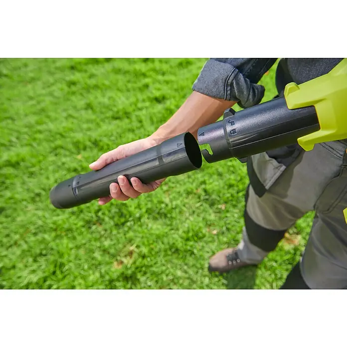 Ryobi ONE+ Akku-Laubbläser RY18BLCXA-0 - 18 V, Ohne Akku, Blasgeschwindigkeit: 241,4 km/h, Blasleistung: 6,51 m³/min - Ein Mann setzt ein schwarzes Blasrohr an einem Laubbläser zusammen. Das Gerät ist für die Gartenarbeit im Freien bestimmt.