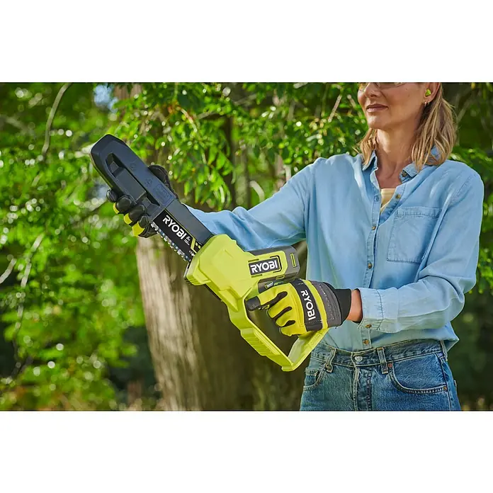 Ryobi ONE+ Akku-Astsäge RY18PS15A-0 - 18 V, Li-Ionen, Ohne Akku, Schwertlänge: 15 cm - Frau hält eine akkubetriebene Ryobi-Kettensäge in der Hand, die zum Beschneiden von Ästen oder kleinen Bäumen verwendet werden kann.
