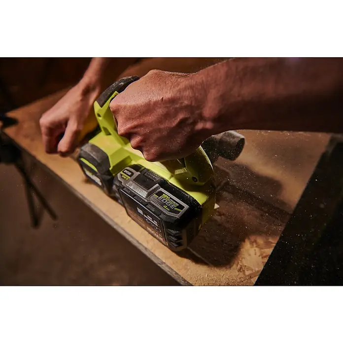 Ryobi ONE+ Akku Edge RB1840E - 18 V, 4 Ah - Ryobi Elektrohobel im Einsatz, der Holz bearbeitet und Späne erzeugt, wobei die Hände das Werkzeug führen.