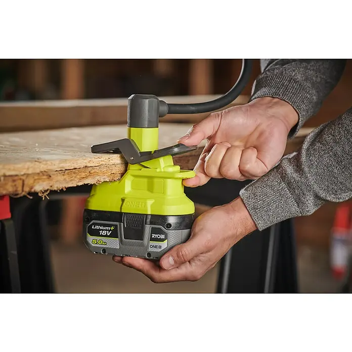 Ryobi ONE+ LED-Akkustrahler RLCF18-0 - 400 lm - Nahaufnahme eines Ryobi ONE+ Akku-Kantenschneiders mit einer Person, die ihn an einem Holzstück befestigt.