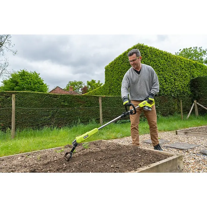 Ryobi ONE+ Akku-Bodenhacke RY18GHA - 18 V, Anzahl Akkus: Ohne Akku, Li-Ionen - Ein Mann benutzt einen Ryobi Kultivator, um den Gartenboden aufzulockern. Das Gartengerät erleichtert die Gartenarbeit enorm.