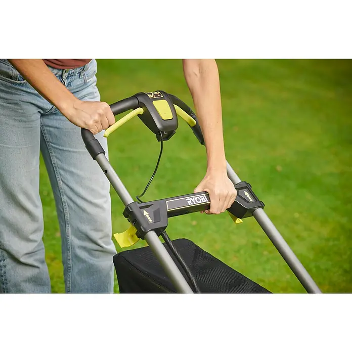 Ryobi ONE+ Akku-Rasenmäher RY18LMX40C-0 - 18 V, Ohne Akku, Schnittbreite: 40 cm - Detailaufnahme eines RYOBI Rasenmähers, der von einer Person bedient wird, Fokus auf die Bedienelemente und das Design.