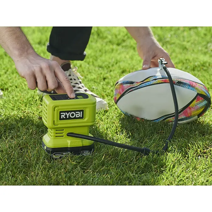 Ryobi ONE+ Akku-Kompressor RPI18-0 - 18 V, Ohne Akku, 10,3 bar - Ryobi Akku-Luftpumpe beim Aufpumpen eines Balls auf Rasen. Kompaktes und tragbares Design für schnelles Aufpumpen unterwegs.
