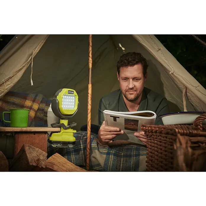Ryobi ONE+ LED-Akkustrahler RLCL18-0 - 18 V, Ohne Akku, 800 lm - Mann liest im Zelt mit einer Ryobi-Lampe, die für ausreichend Licht sorgt. Perfekt für Campingausflüge!