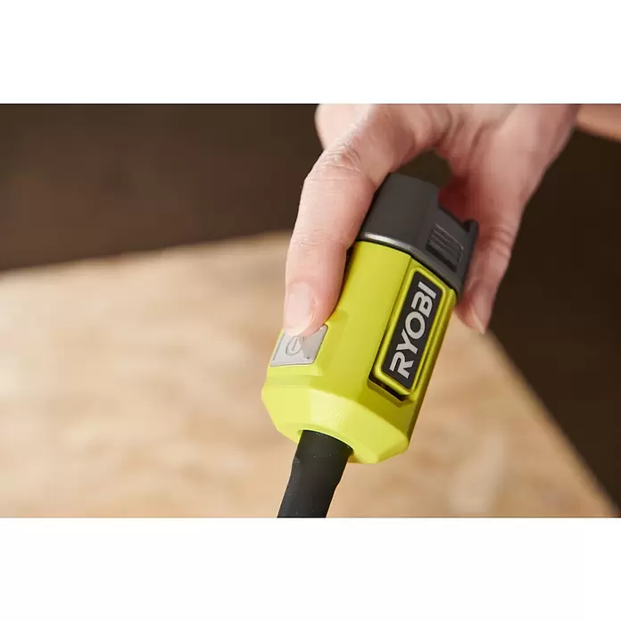Ryobi ONE+ LED-Akkustrahler RLCF18-0 - 400 lm - Eine Hand drückt den Einschaltknopf eines lindgrünen und schwarzen Ryobi-Werkzeugs.