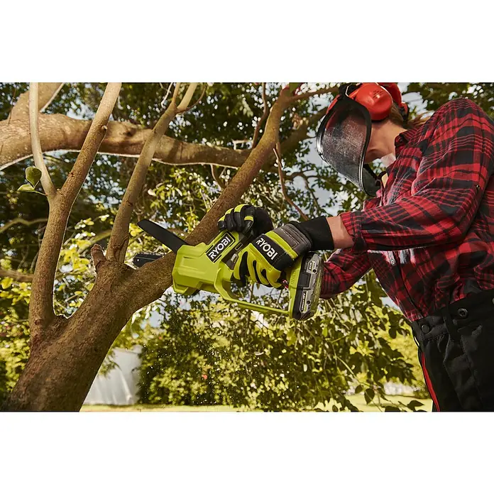 Ryobi ONE+ Akku-Astsäge RY18PS15A-0 - 18 V, Li-Ionen, Ohne Akku, Schwertlänge: 15 cm - Nahaufnahme einer Person, die mit einer RYOBI Akku-Astsäge einen Baum beschneidet, mit Schutzvisier und Handschuhen für sicheres Arbeiten.