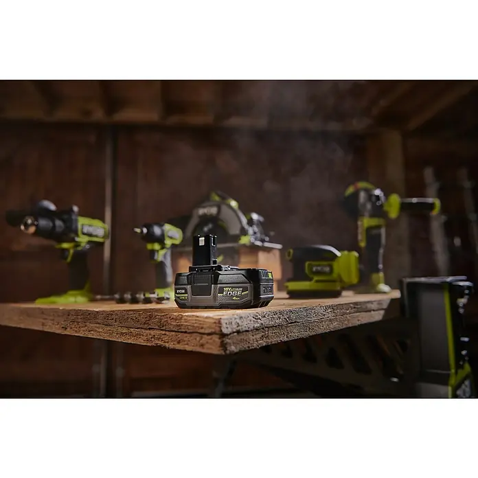 Ryobi ONE+ Akku Edge RB1840E - 18 V, 4 Ah - Nahaufnahme eines RYOBI 18V Lithium EDGE 4Ah Akkus auf einer Werkbank, umgeben von verschiedenen RYOBI-Elektrowerkzeugen.