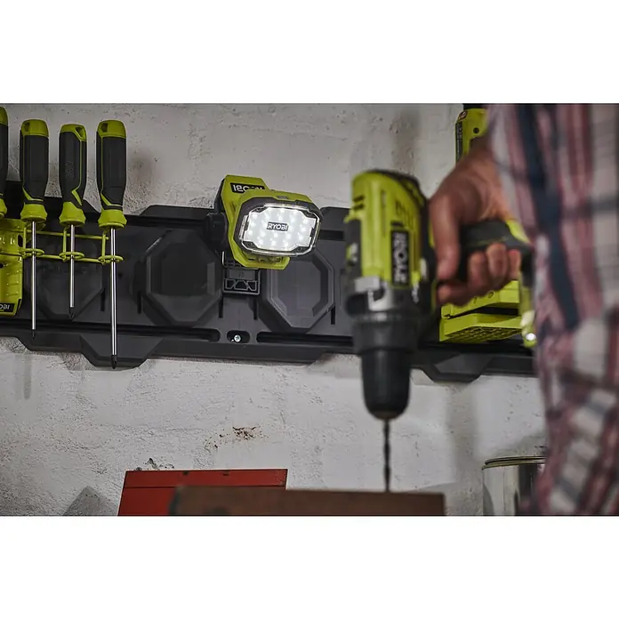 Ryobi 4V USB LED-Akkustrahler RLC4-0 - 1.000 lm - Eine Ryobi Werkstatt mit Werkzeugaufbewahrung und Akkuschrauber. Die Ryobi Werkzeuge sind an einer grauen Werkzeugwand angebracht.