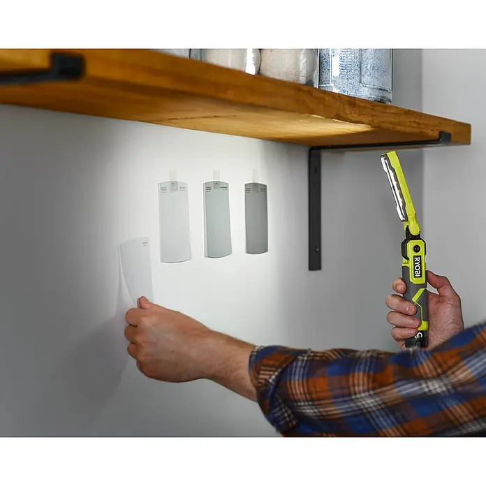 Ryobi 4V USB Akku-Stableuchte RLI4-120G - 4 V, 1 Akku, 2 Ah - Ein Mann wählt mit einer Ryobi-Arbeitsleuchte Farben für Wände aus, um die Farbtöne besser beurteilen zu können.